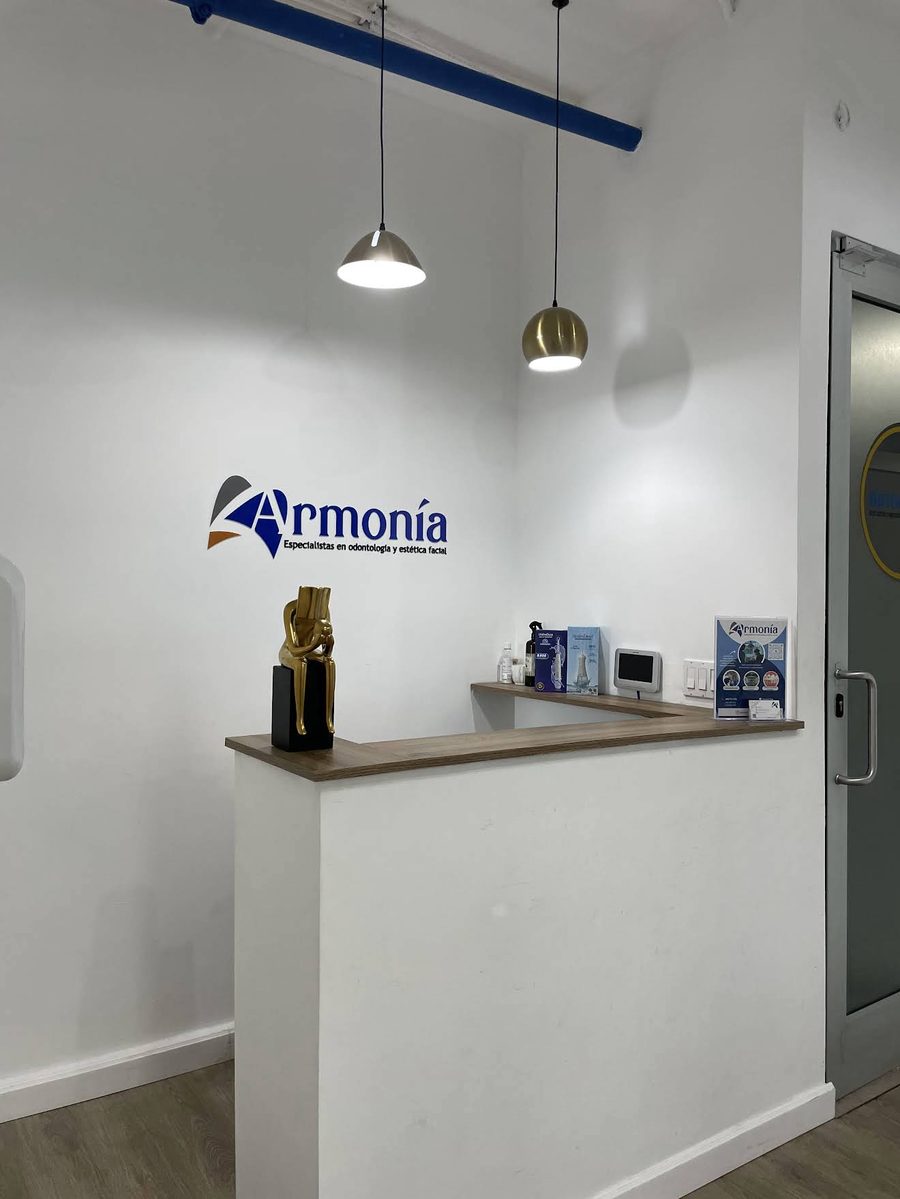 Recepción de Armonía con el logo en la pared y lámparas colgantes
